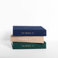 Stack of travel journals in three colors